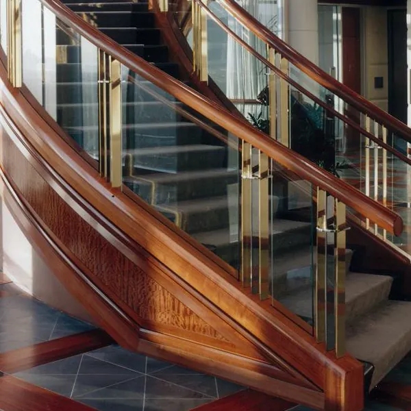 Curved mahogany staircase with brass and glass balustrade at Wells Fargo Center