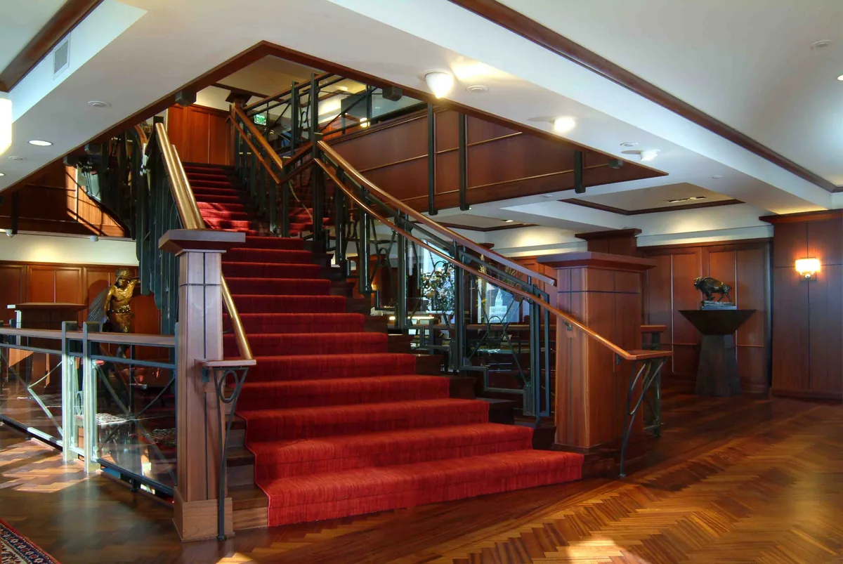 Carpeted stair with wood newels, rails and wall paneling in the Van Cott Bagley offices
